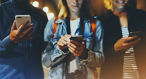 Trois personnes qui consultent leur portable